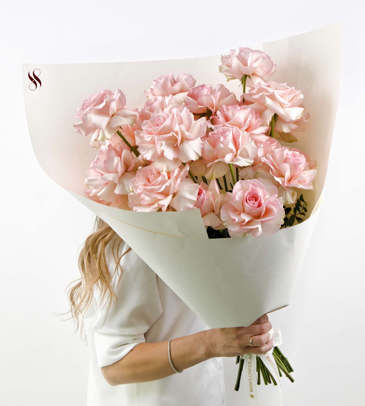 Soft pink roses with ruffled edges arranged in an elegant bouquet.