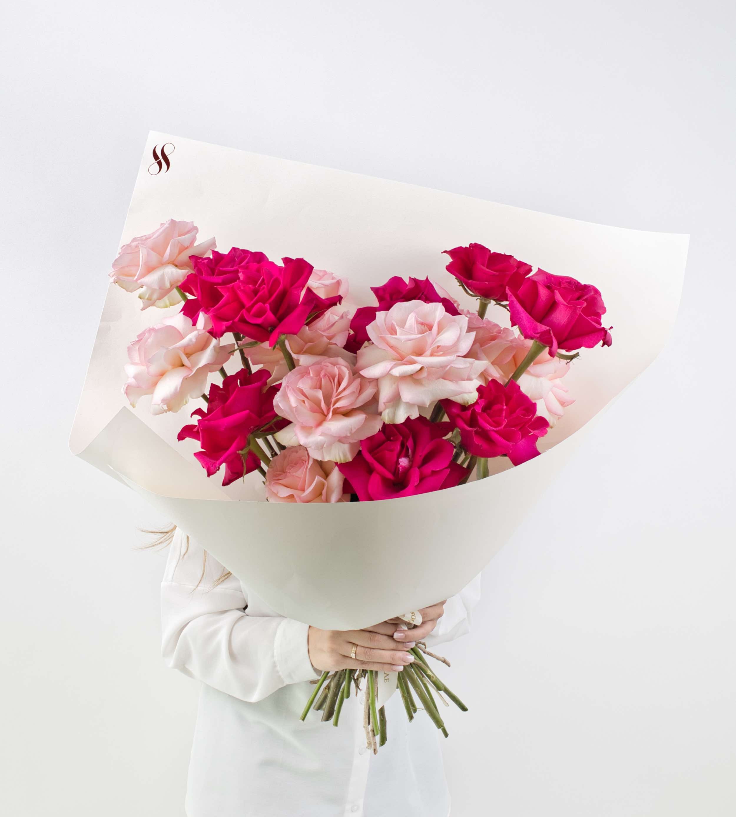 Bouquet of blush and crimson roses symbolizing love and elegance.
