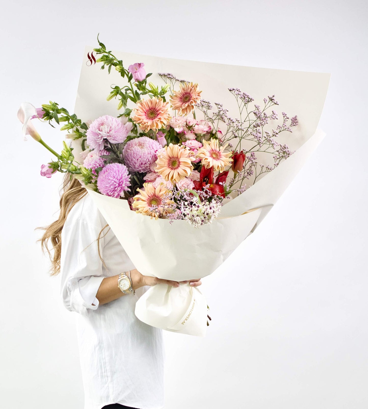 bouquet with pink and purple flowers arranged with sculptural stems in a graceful artistic style.