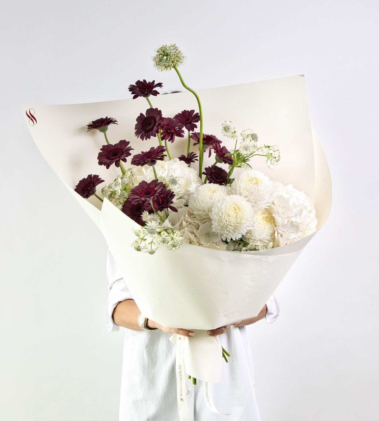 bouquet with burgundy gerberas, white hydrangeas, and chrysanthemums.