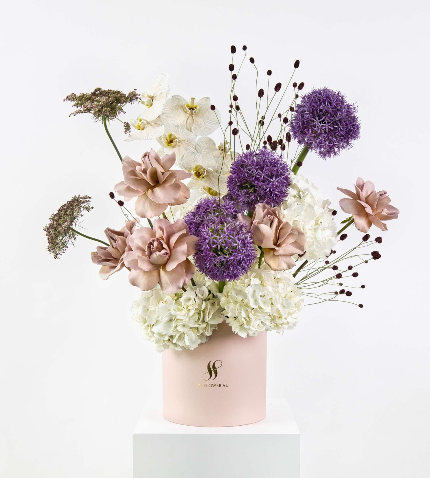 Plum Mirage bouquet with blush roses, purple alliums, white orchids, and soft hydrangeas.