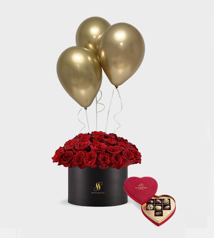 Romantic red rose bouquet with gold balloons and luxury chocolates in a black vase — perfect gift for love and special occasions.