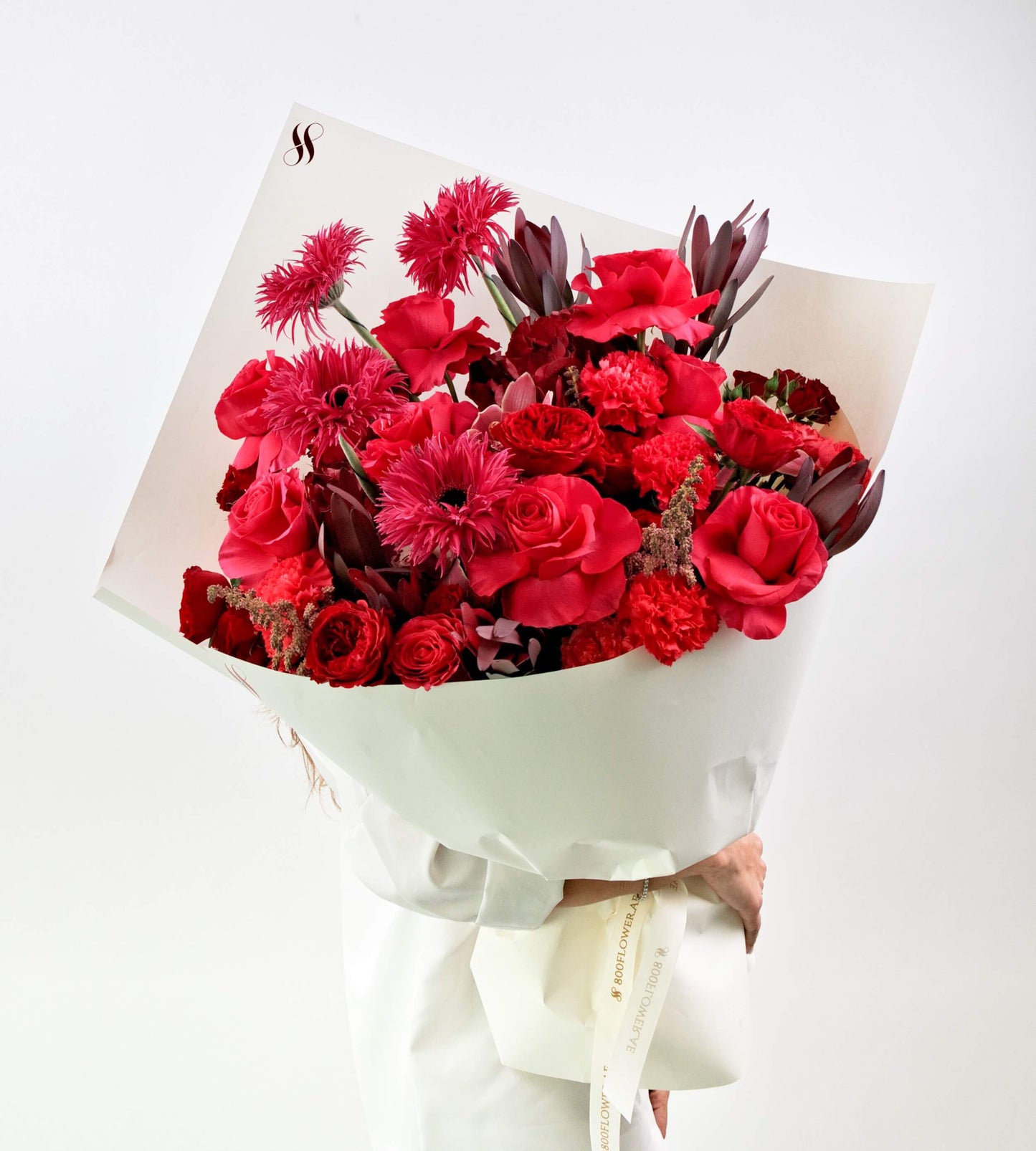 Fiery red bouquet with roses, carnations, and gerberas – perfect for romantic or bold occasions.