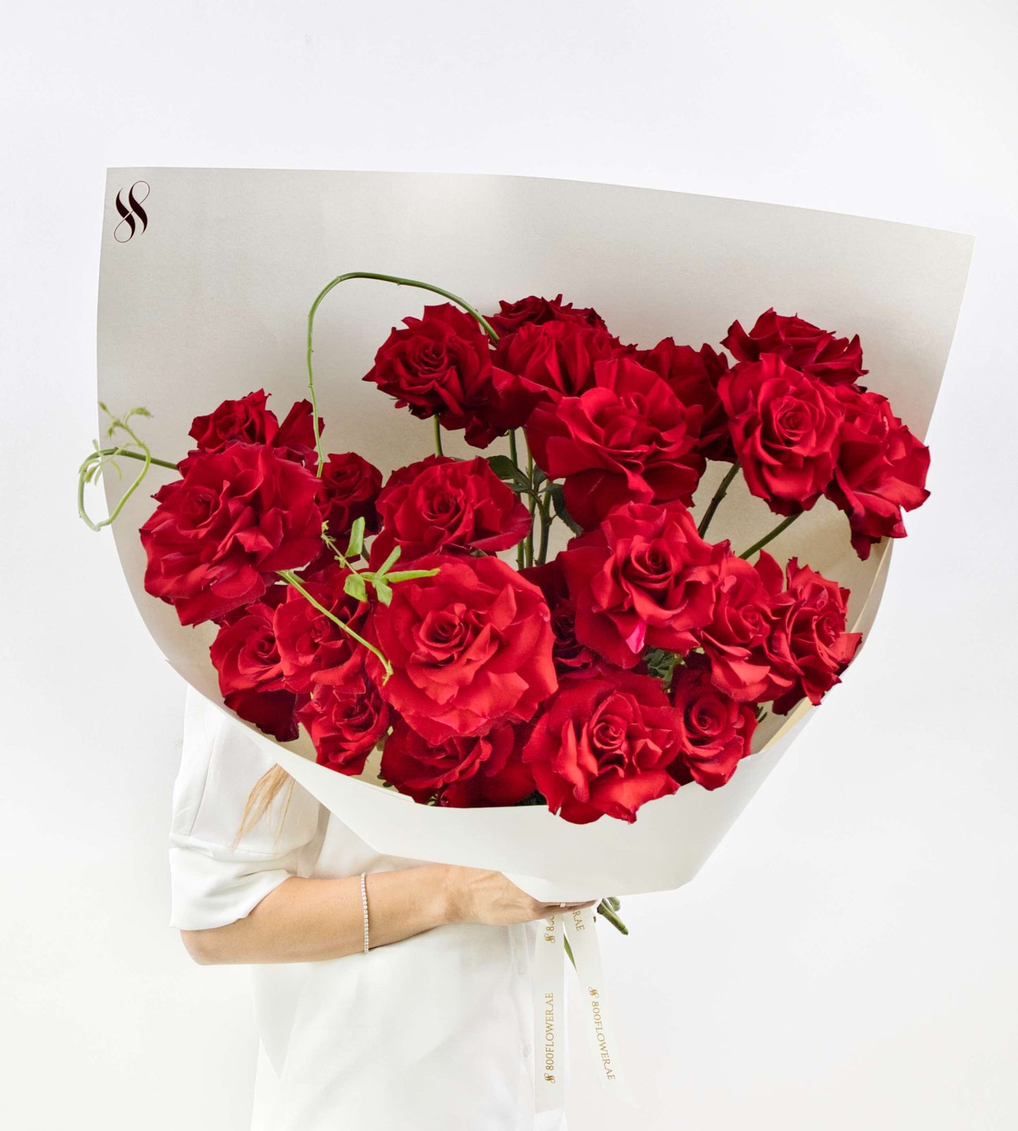 Luxurious bouquet of red roses with soft greenery.