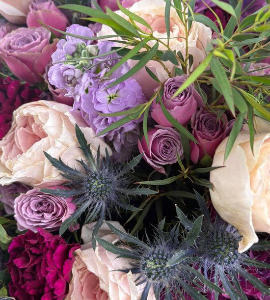 A dreamy mix of blush, violet, and wine-toned blooms with soft greens woven through. Twilight Muse captures the mood of a slow sunset and the beauty that lingers after.