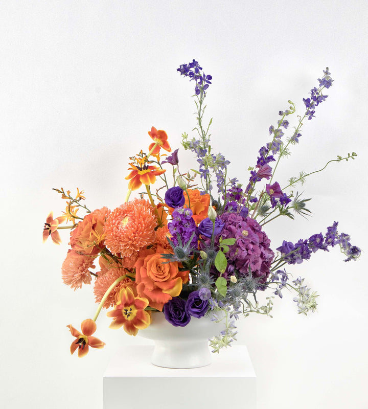 Vibrant bouquet of tangerine and violet flowers.