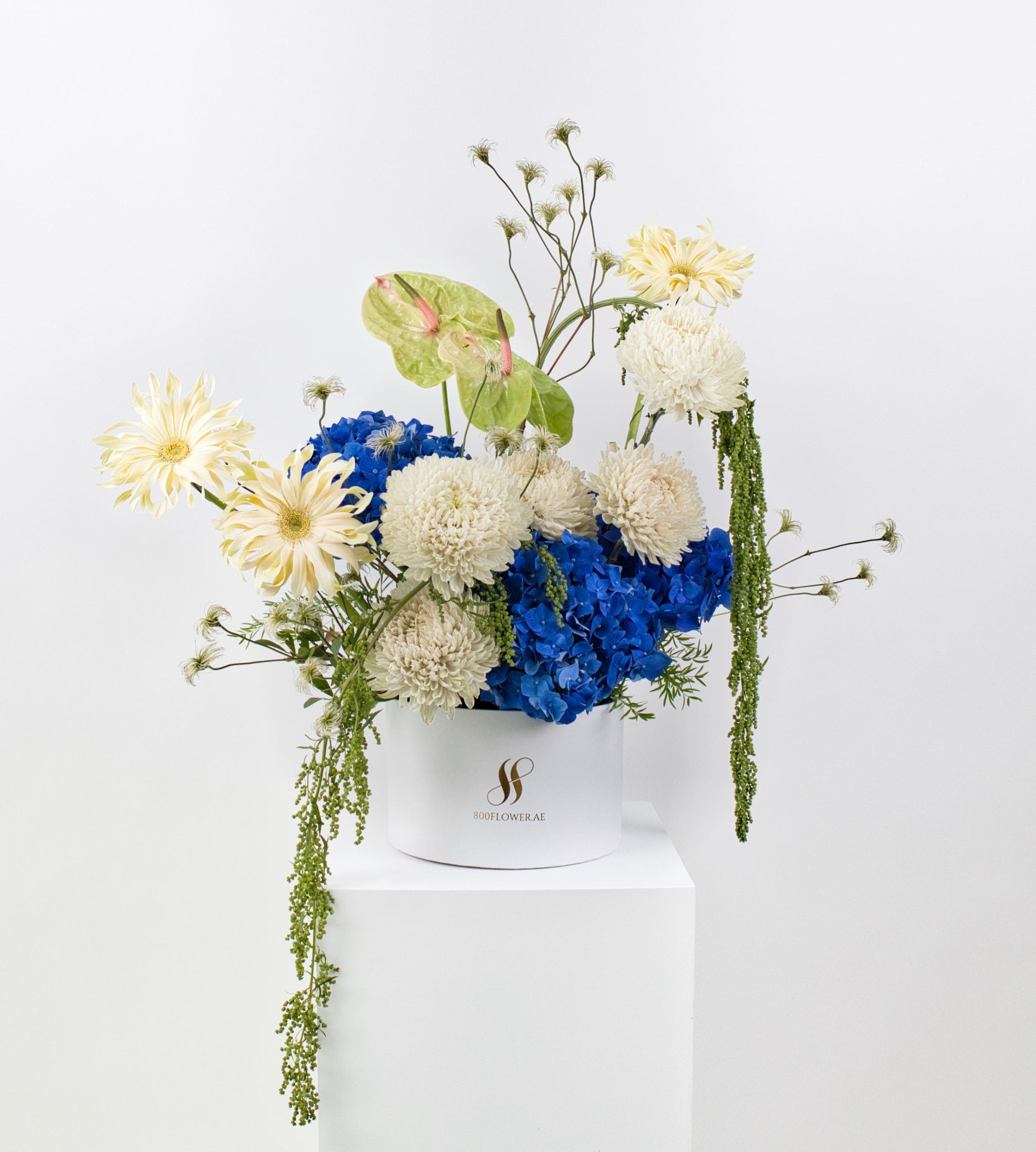 Bouquet of creamy flowers with bold blue hydrangeas.