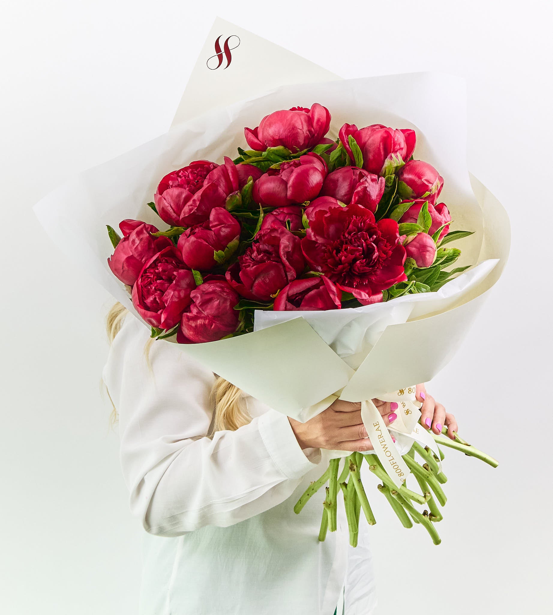 Red Charm peonies bouquet with deep crimson petals and lush, velvety texture.